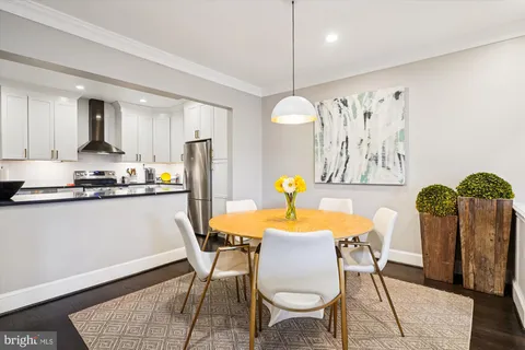 a kitchen with stainless steel appliances kitchen island a table and chairs in it