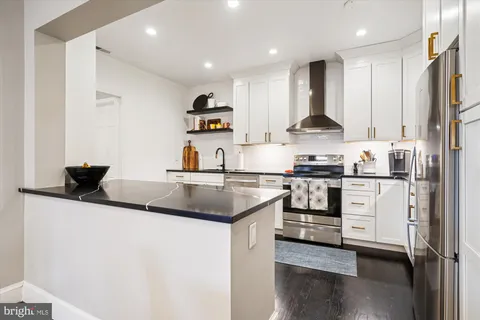 a kitchen with stainless steel appliances granite countertop a sink and a refrigerator