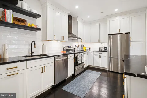 a kitchen with white cabinets and white appliances