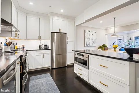 a kitchen with a refrigerator and white cabinets
