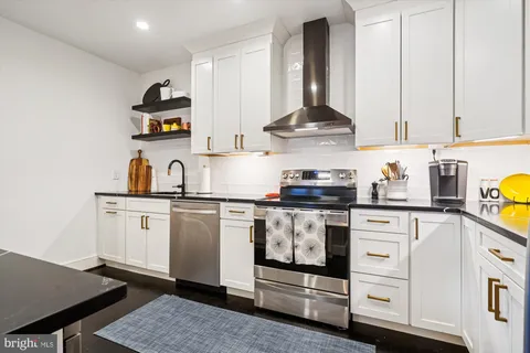 a kitchen with white cabinets and appliances