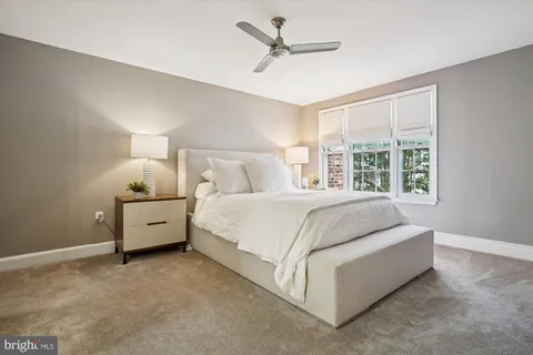 a bed room with a bed and a ceiling fan