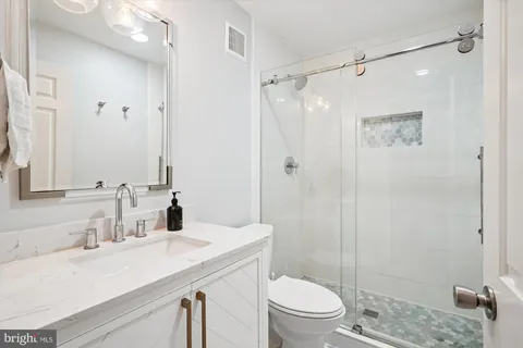 a bathroom with a sink toilet vanity and shower