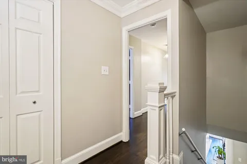 a view of a hallway with wooden floor and a bathroom