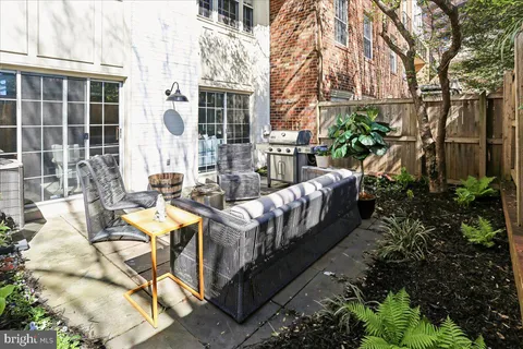 a view of a patio with couches table and chairs and potted plants