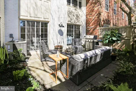 a view of a patio with couches table and chairs and potted plants