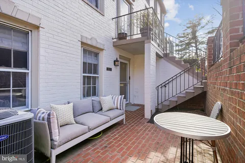a view of a patio with couches table and chairs and wooden floor