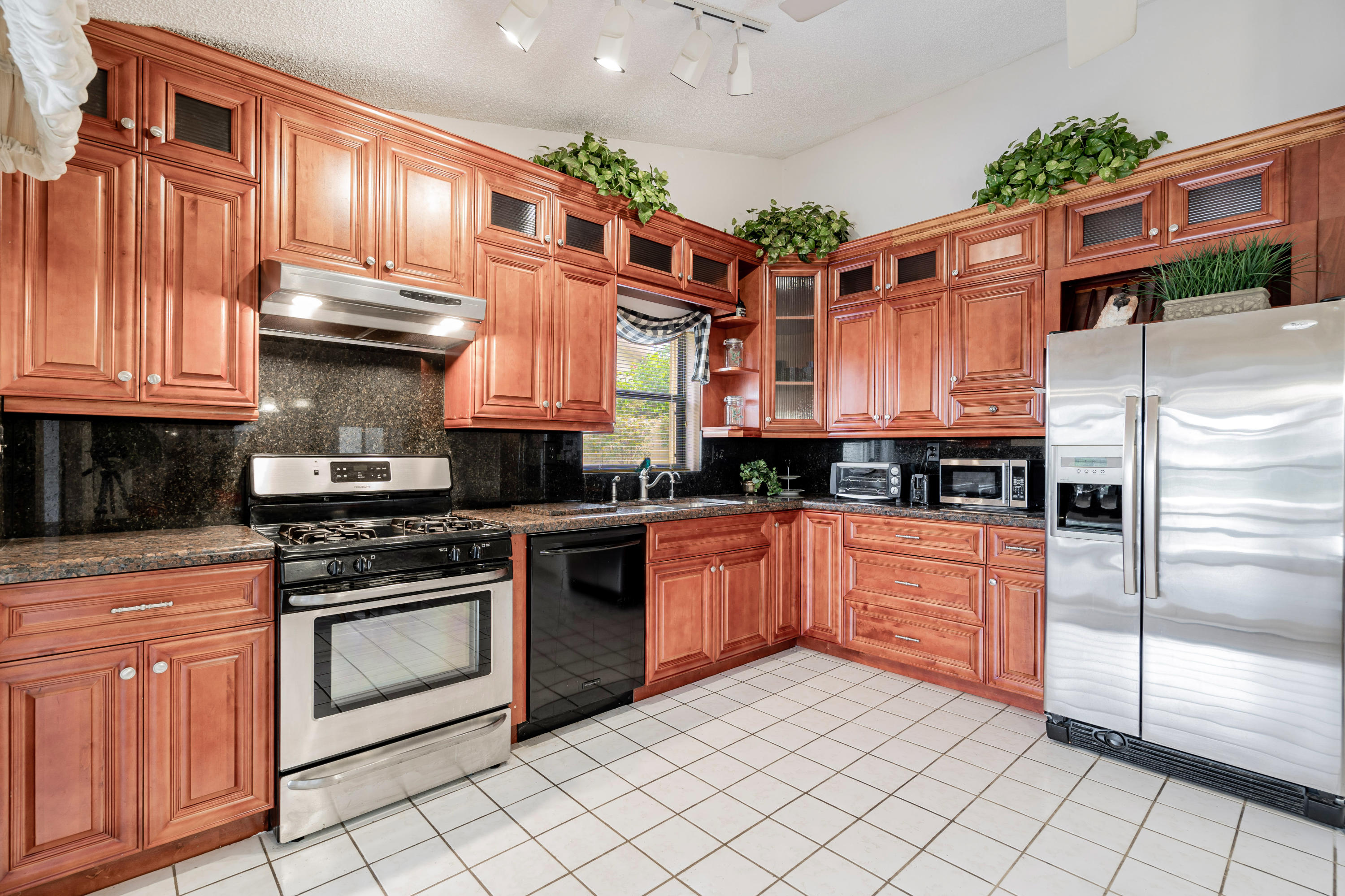 861 Camino Gardens Lane Boca Raton, FL 33432 - Photo 15 of 37 a kitchen with stainless steel appliances granite countertop a stove a sink and a microwave