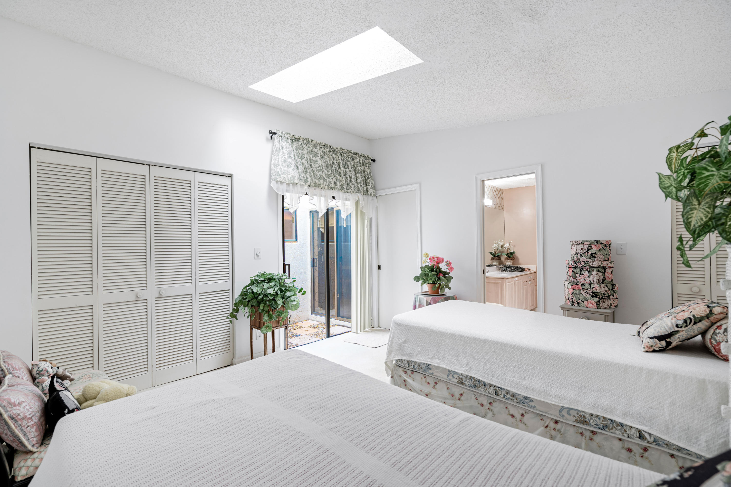 861 Camino Gardens Lane Boca Raton, FL 33432 - Photo 19 of 37 a bedroom with a large bed and potted plant