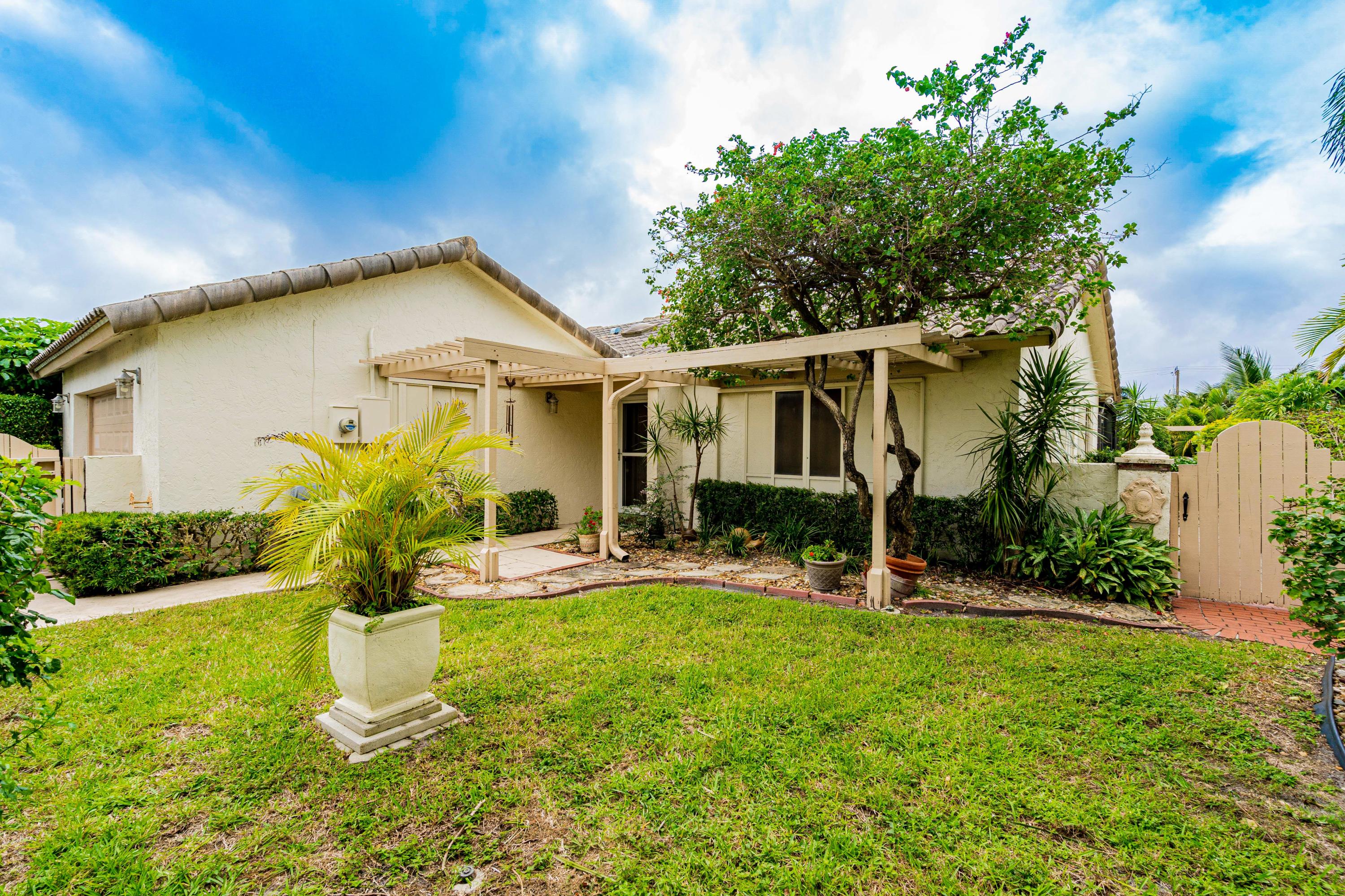 861 Camino Gardens Lane Boca Raton, FL 33432 - Photo 31 of 37 a front view of house with yard and outdoor seating