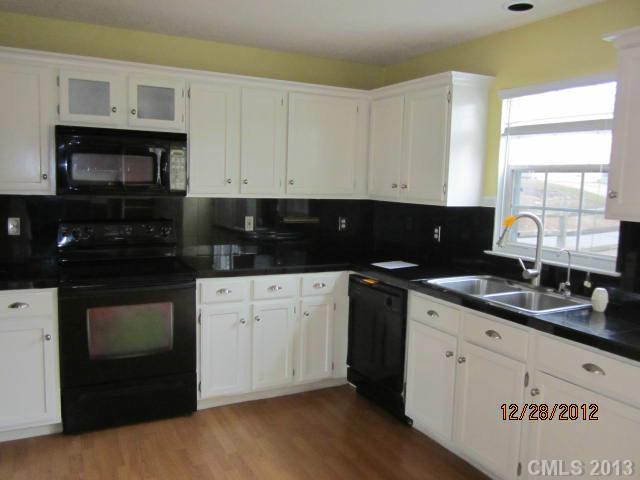 1901 Pine Mountain Road Charlotte, NC 28214 - Photo 4 of 10 a kitchen with granite countertop white cabinets and black appliances