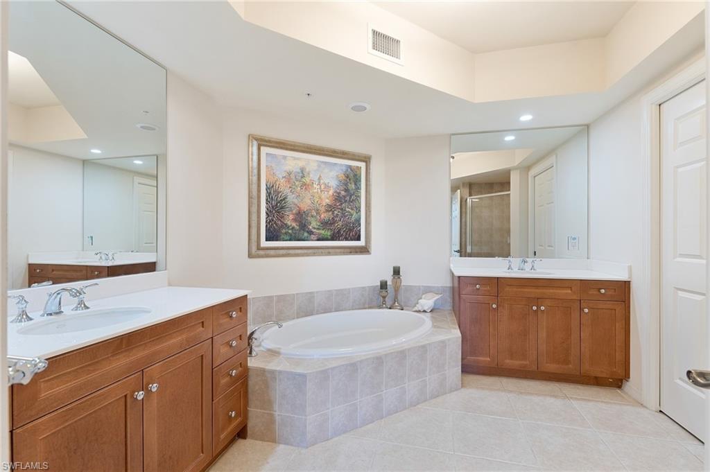 1065 Borghese Lane, Unit 203 Naples, FL 34114 - Photo 11 of 24 a spacious bathroom with a tub double sink window and mirror