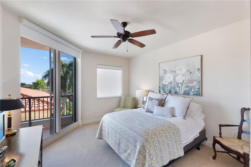 1065 Borghese Lane, Unit 203 Naples, FL 34114 - Photo 12 of 24 a bedroom with a large bed and a chandelier fan