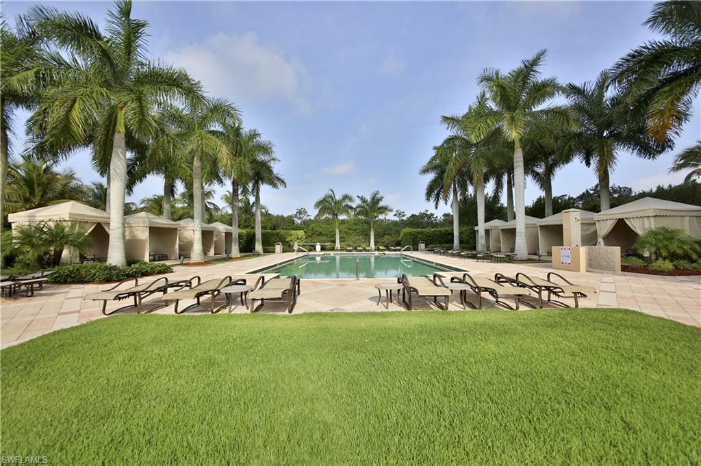 1065 Borghese Lane, Unit 203 Naples, FL 34114 - Photo 3 of 24 a view of a swimming pool with a garden and palm trees