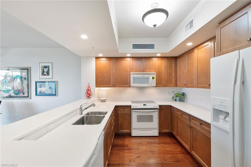 1065 Borghese Lane, Unit 203 Naples, FL 34114 - Photo 8 of 24 a kitchen with stainless steel appliances a refrigerator sink and white cabinets
