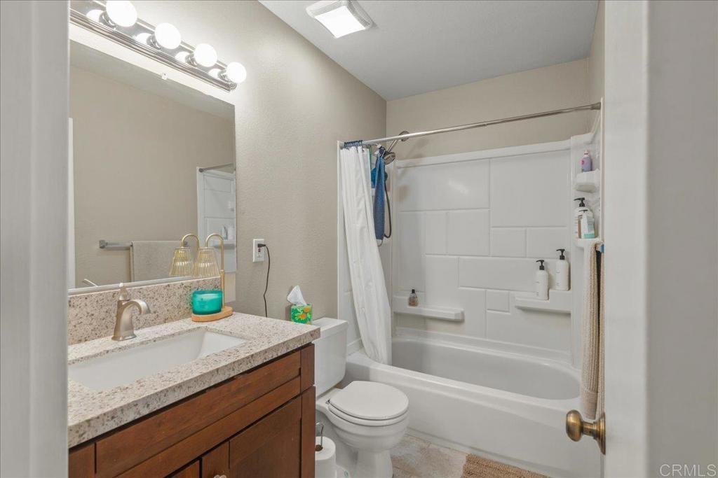3047 Highlands Boulevard Spring Valley, CA 91977 - Photo 24 of 39 a bathroom with a granite countertop sink a toilet a mirror and shower