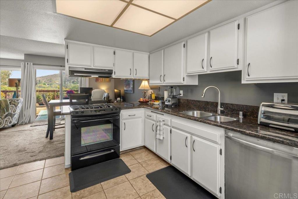 3047 Highlands Boulevard Spring Valley, CA 91977 - Photo 11 of 39 a kitchen with cabinets stainless steel appliances and sink