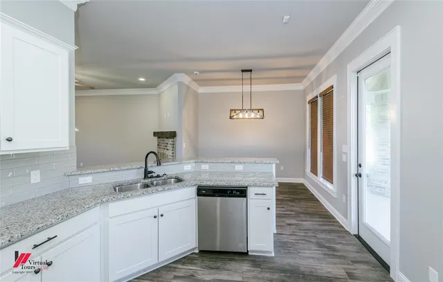 a kitchen with granite countertop a sink and dishwasher with wooden floor