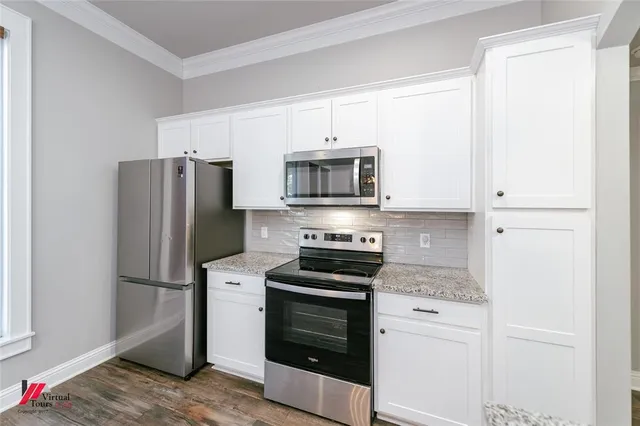 a kitchen with white cabinets and stainless steel appliances