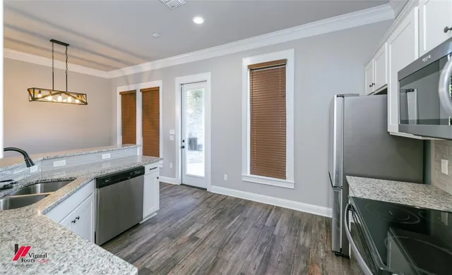 a kitchen with stainless steel appliances granite countertop a sink stove and refrigerator