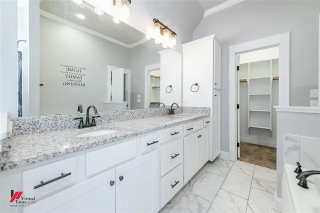 a spacious bathroom with a granite countertop sink and a mirror