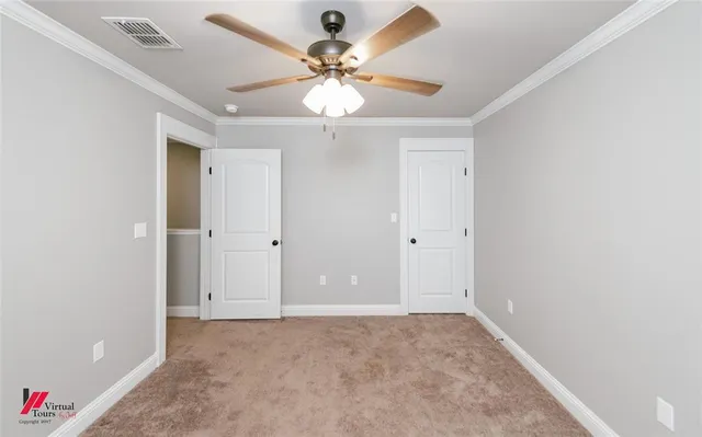 an empty room with closet and a ceiling fan