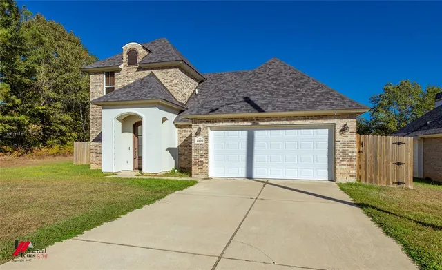 a front view of a house with a garden and yard