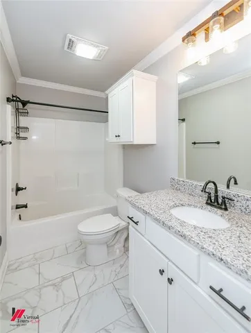 a bathroom with a granite countertop sink a toilet and shower