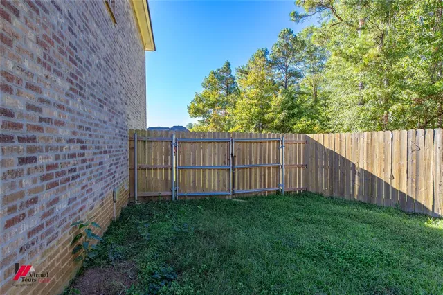 a view of a backyard with wooden fence