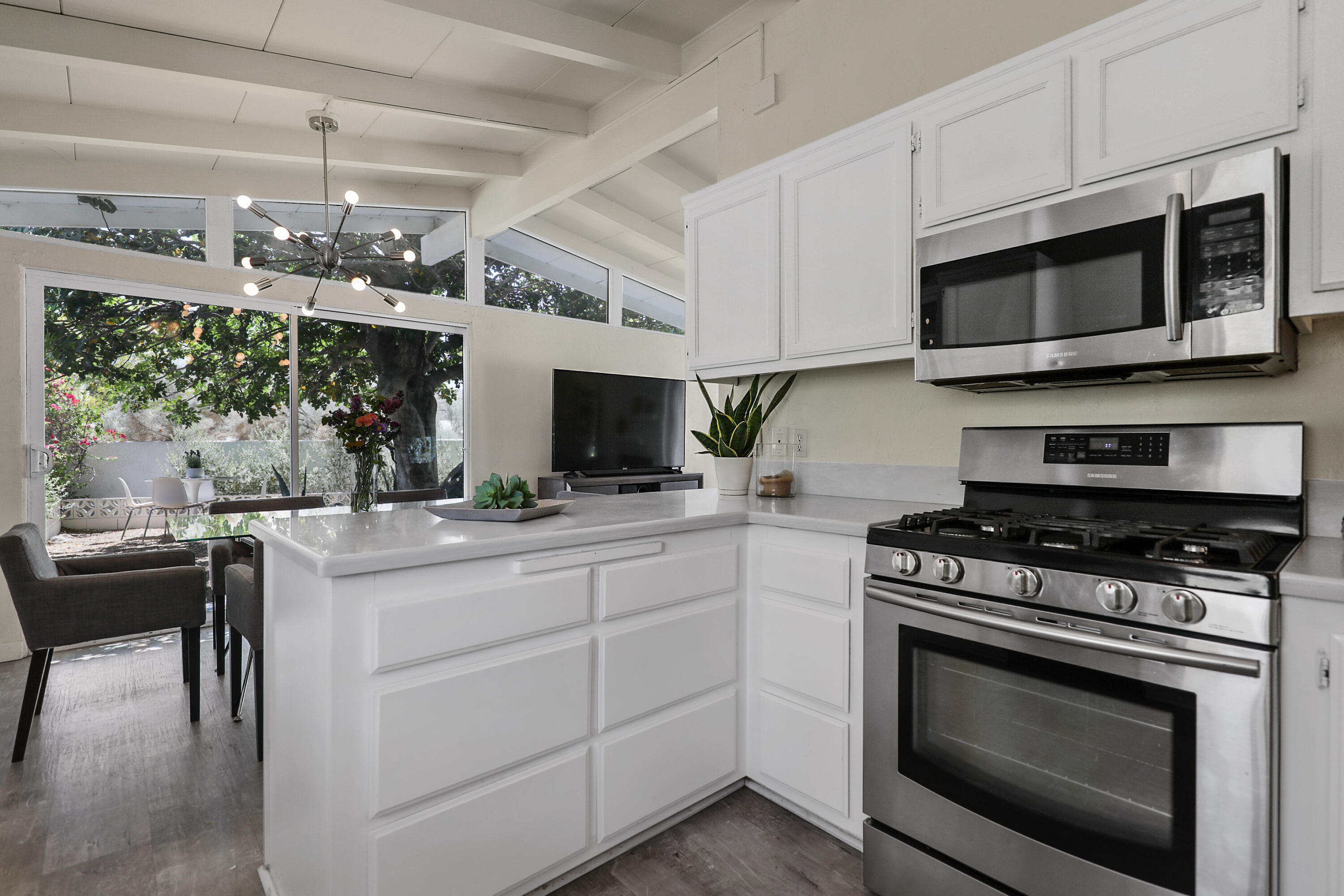 71767 Tunis Road Rancho Mirage, CA 92270 - Photo 10 of 30 a kitchen with stainless steel appliances a stove microwave and cabinets