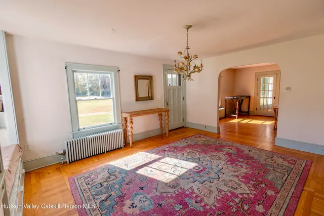 a view of a hallway with wooden floor and windows