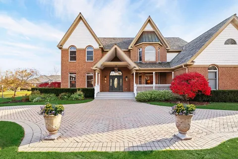 a front view of a house with a yard and potted plants