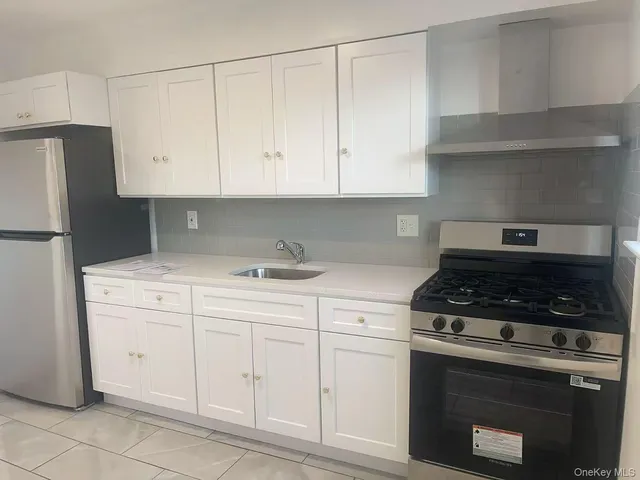 a kitchen with white cabinets and appliances