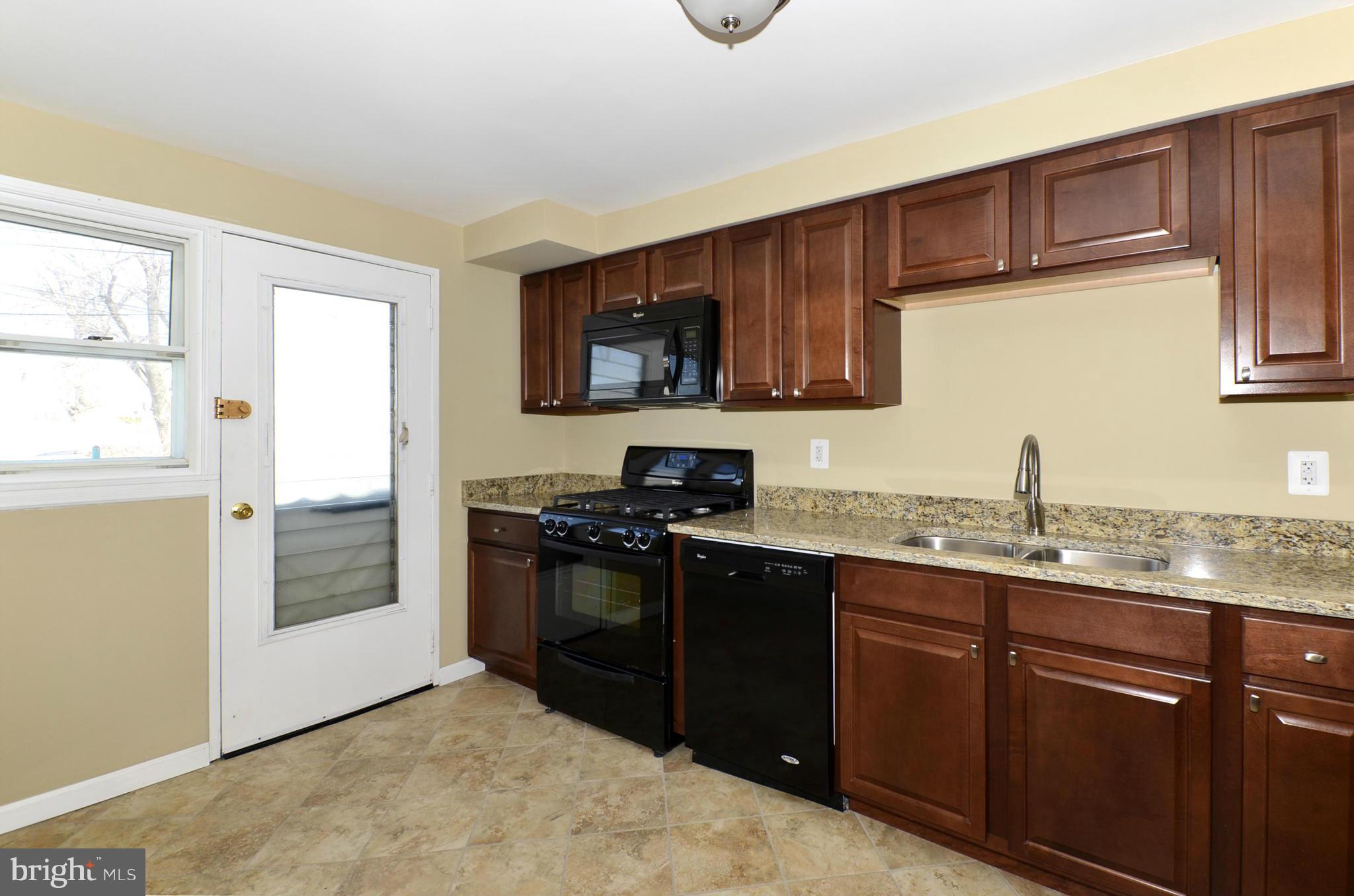 8058 Stratman Road Baltimore, MD 21222 - Photo 2 of 30 a kitchen with stainless steel appliances granite countertop a stove a sink and a microwave