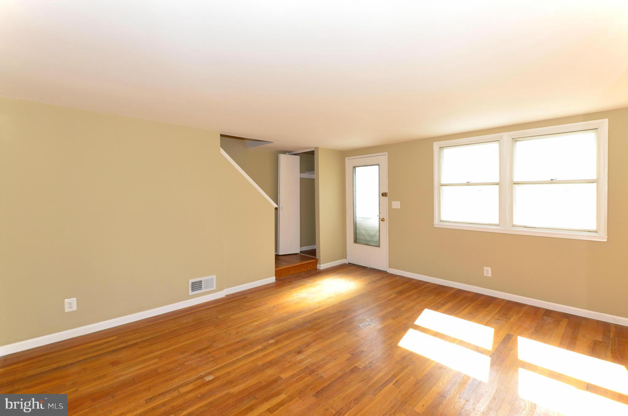 8058 Stratman Road Baltimore, MD 21222 - Photo 12 of 30 an empty room with wooden floor and windows
