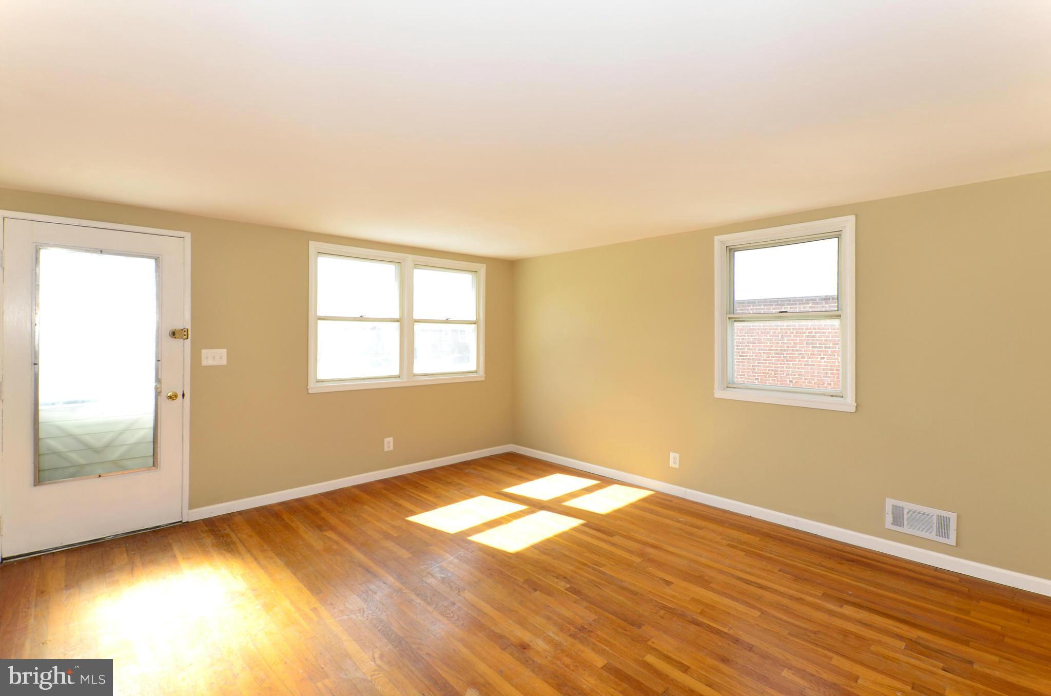 8058 Stratman Road Baltimore, MD 21222 - Photo 13 of 30 a view of empty room with wooden floor and fan