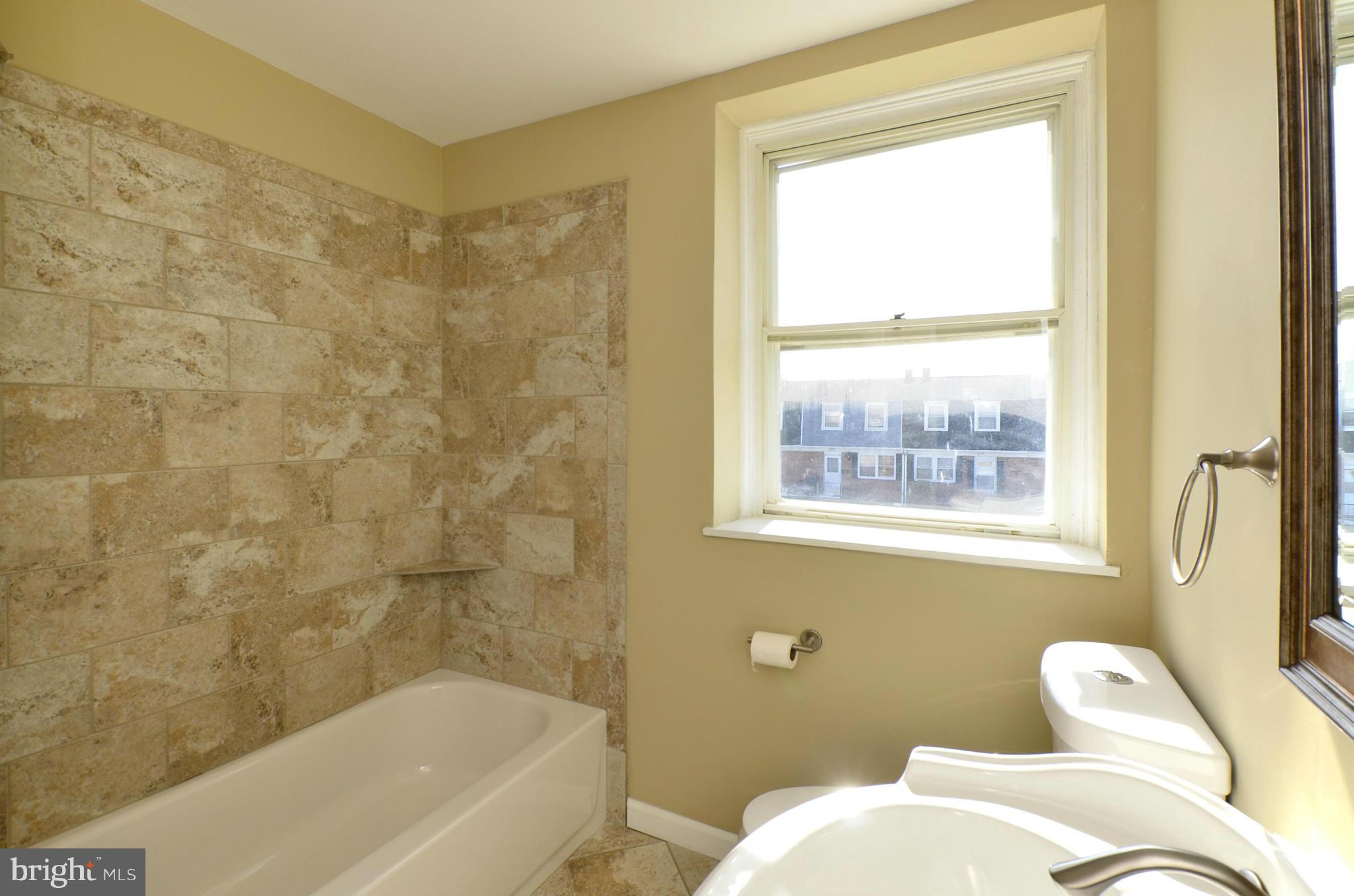 8058 Stratman Road Baltimore, MD 21222 - Photo 14 of 30 a bathroom with a bathtub and window