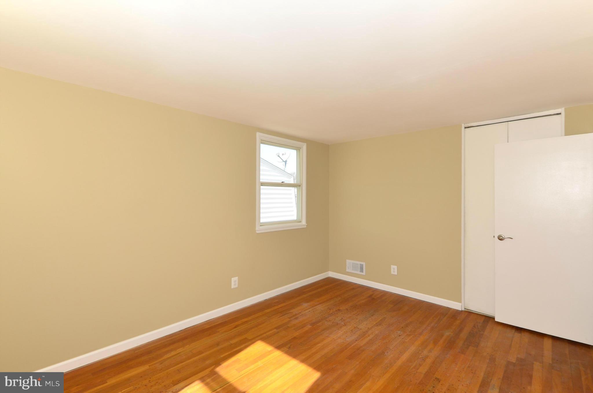 8058 Stratman Road Baltimore, MD 21222 - Photo 17 of 30 an empty room with wooden floor and windows