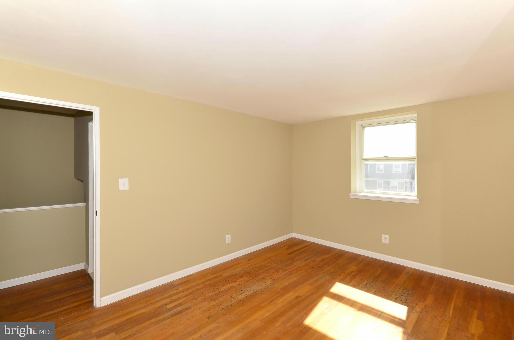 8058 Stratman Road Baltimore, MD 21222 - Photo 19 of 30 an empty room with wooden floor and windows