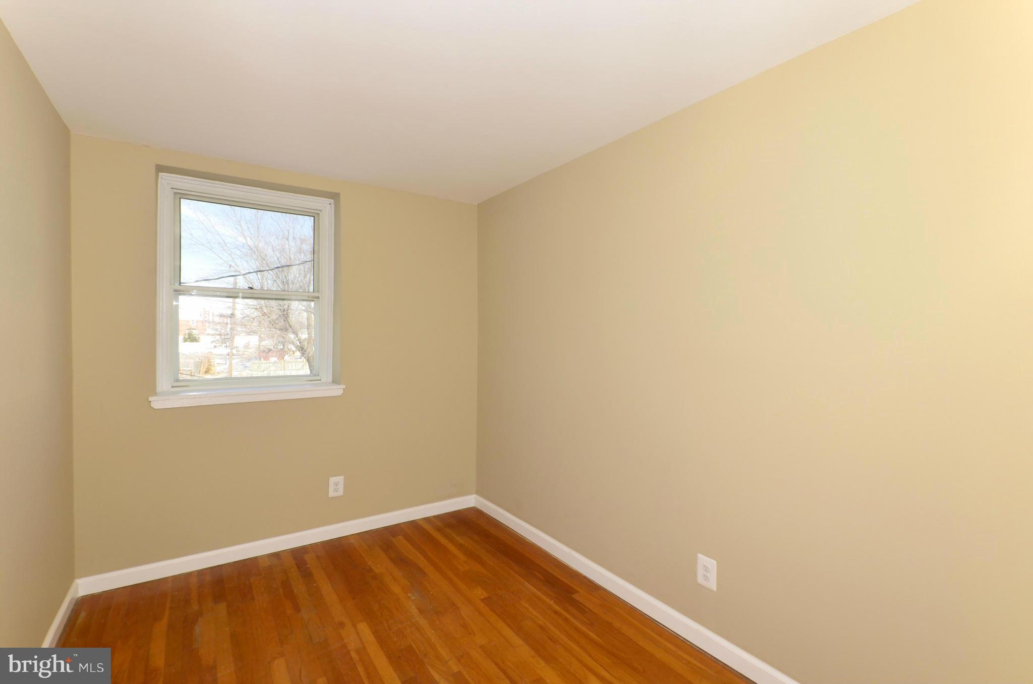 8058 Stratman Road Baltimore, MD 21222 - Photo 20 of 30 a view of an empty room with wooden floor and a window