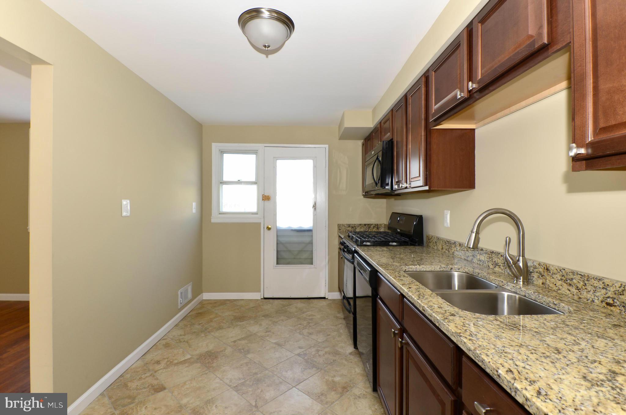 8058 Stratman Road Baltimore, MD 21222 - Photo 3 of 30 a kitchen with stainless steel appliances granite countertop a sink stove and cabinets