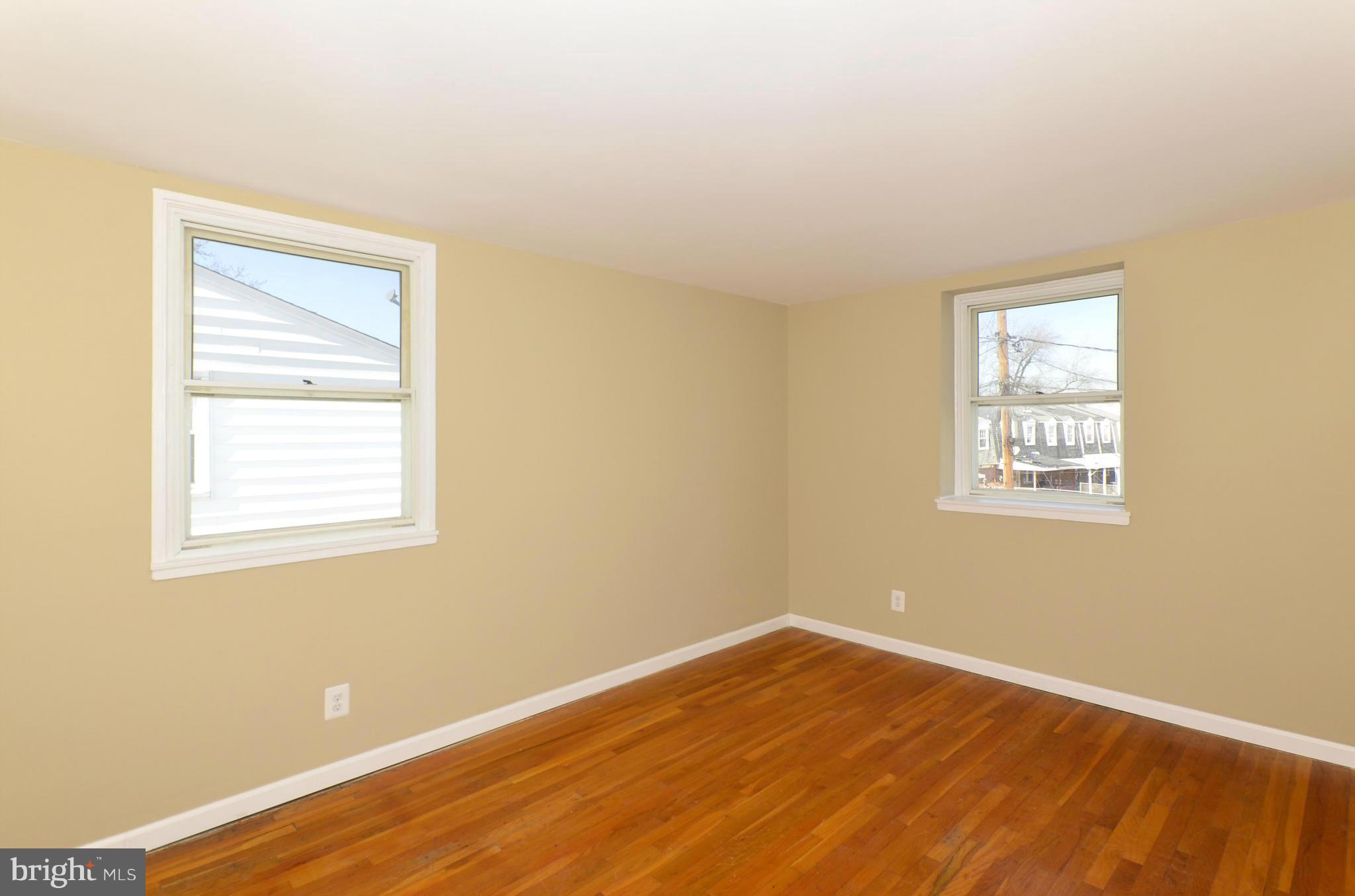 8058 Stratman Road Baltimore, MD 21222 - Photo 23 of 30 a view of an empty room with wooden floor and a window
