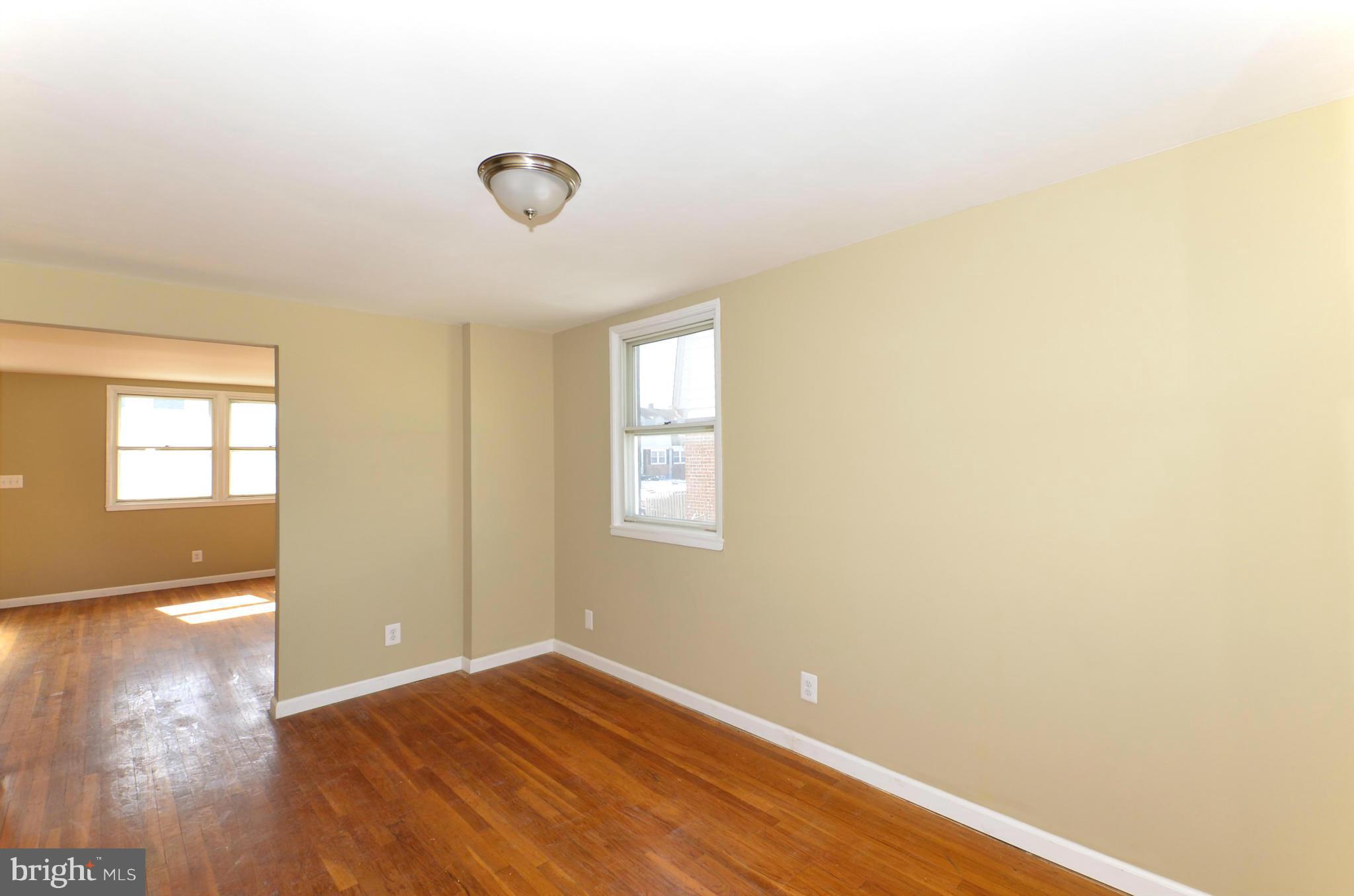 8058 Stratman Road Baltimore, MD 21222 - Photo 7 of 30 a view of empty room with wooden floor and fan