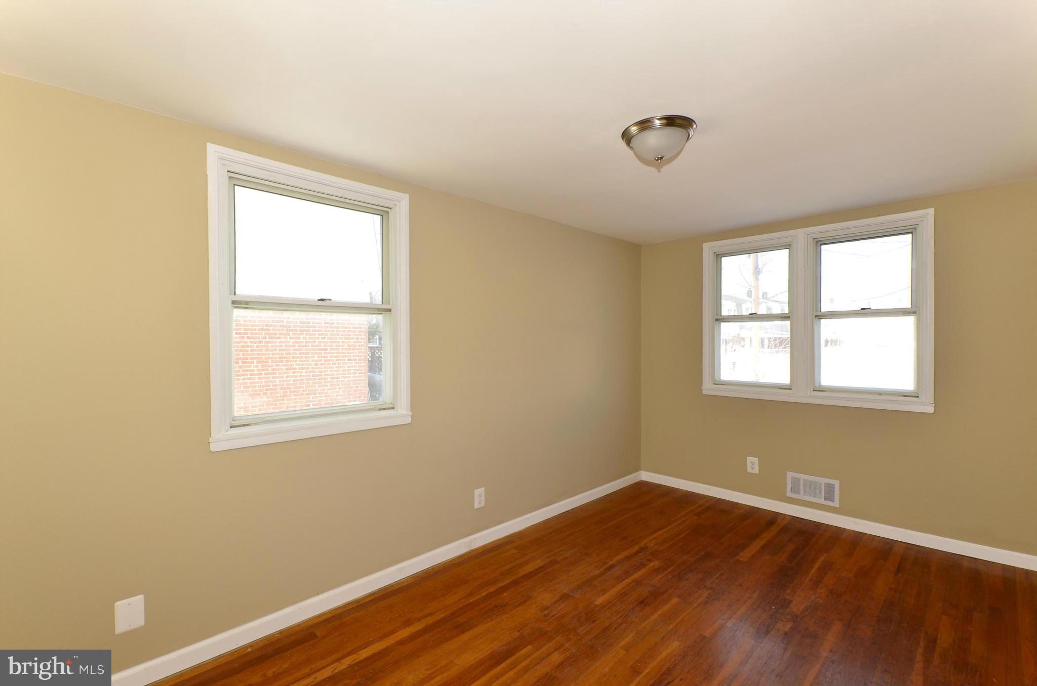 8058 Stratman Road Baltimore, MD 21222 - Photo 9 of 30 a view of an empty room with wooden floor and a window