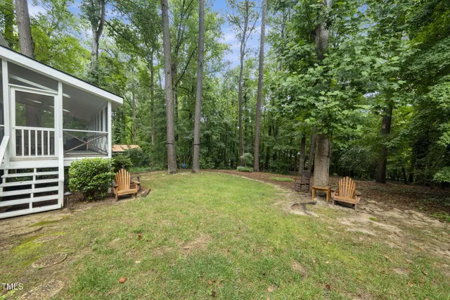 a view of a house with backyard and trees