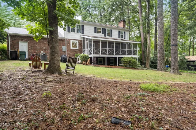 an aerial view of residential house with outdoor space and trees all around
