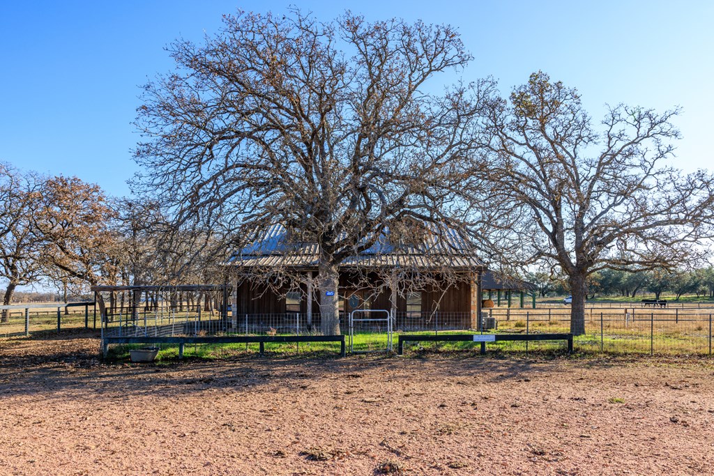 485 Fulton Ranch Road Stonewall, TX 78671 - Photo 17 of 22 a view of a house with a yard and large trees