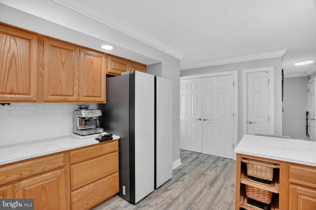 a kitchen with stainless steel appliances white cabinets and wooden floor
