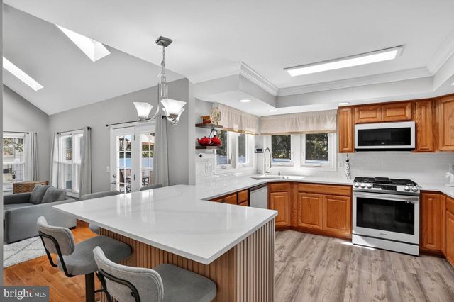 a kitchen with stainless steel appliances granite countertop a stove refrigerator and microwave