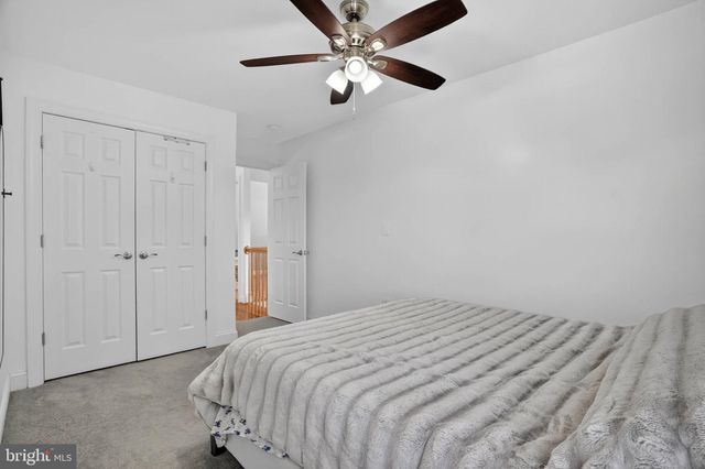 a bedroom with a bed and a ceiling fan